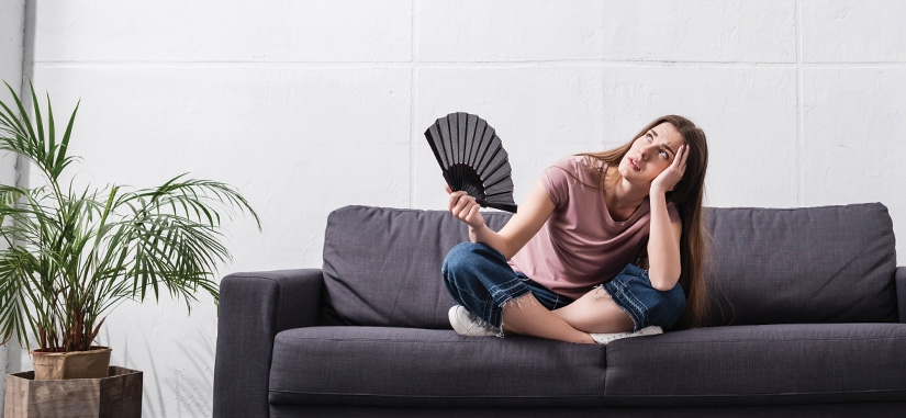 Femme sur son canapé qui a chaud