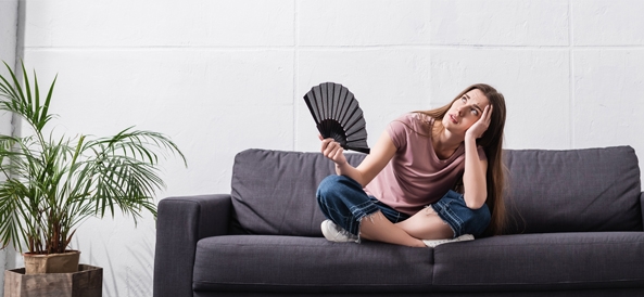 Femme sur son canapé qui a chaud