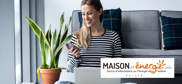 Femme assise par terre confortablement avec son ordi sur ses genoux et son téléphone à la main