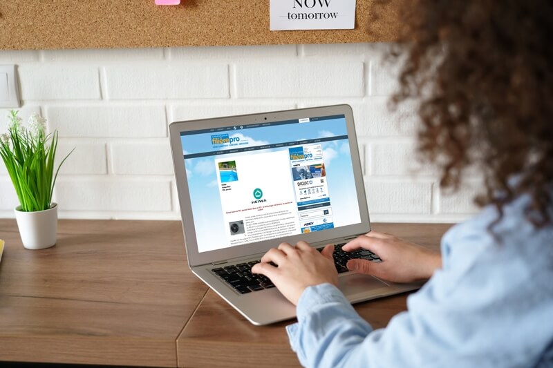 Femme assise devant son ordinateur dans un bureau et regarde un article sur Heiwa dans Filière Pro Magazine