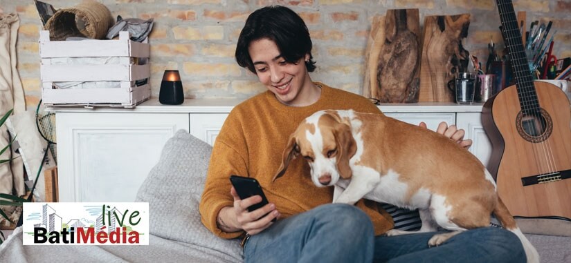 jeune homme qui regarde son téléphone avec son chien