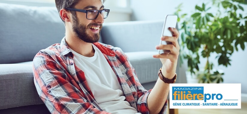 jeune homme qui regarde son téléphone assis par terre