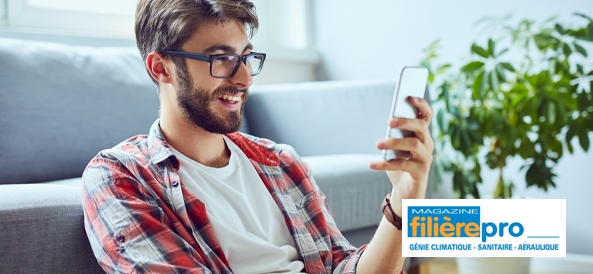 jeune homme qui regarde son téléphone assis par terre